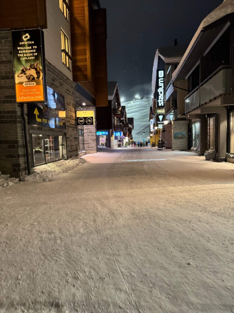 Levi village street with floodlit slopes behind