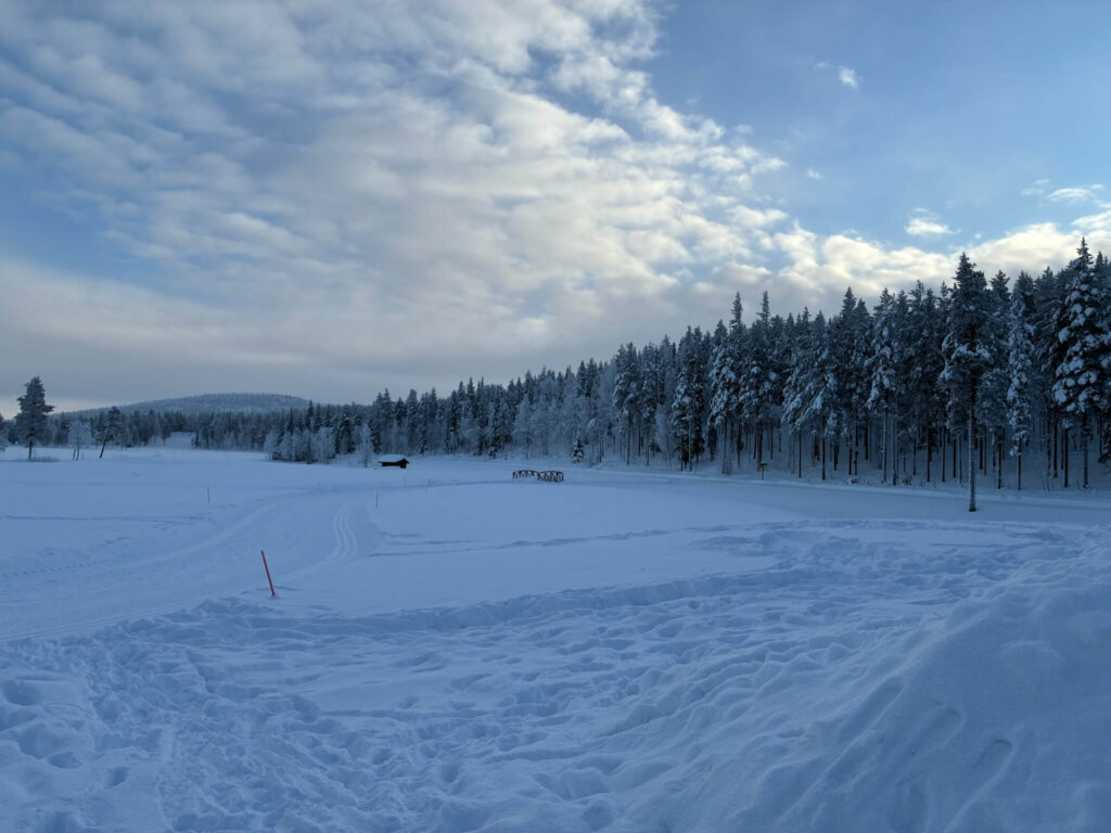 Snow-covered Levi golf course and surrounding forest