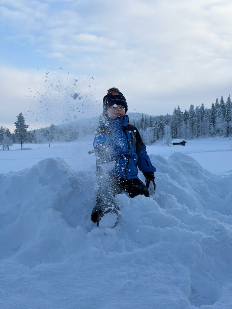 Child throwing snow at Levi golf course