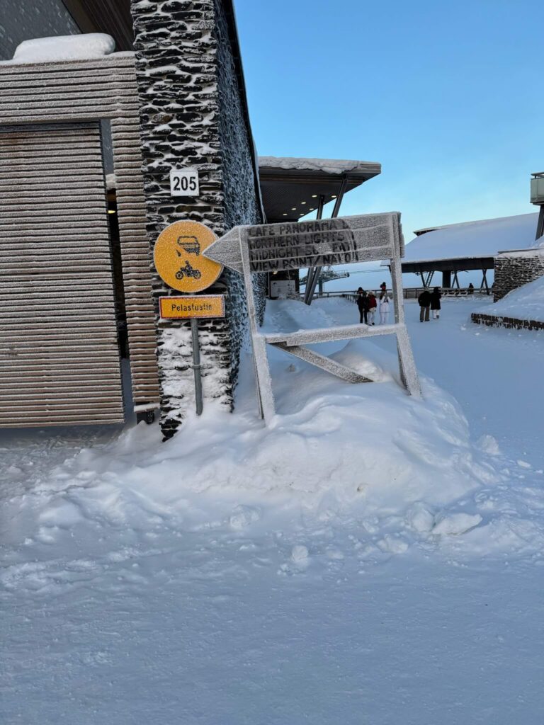 Snow-covered sign pointing towards Levi’s Secret Café