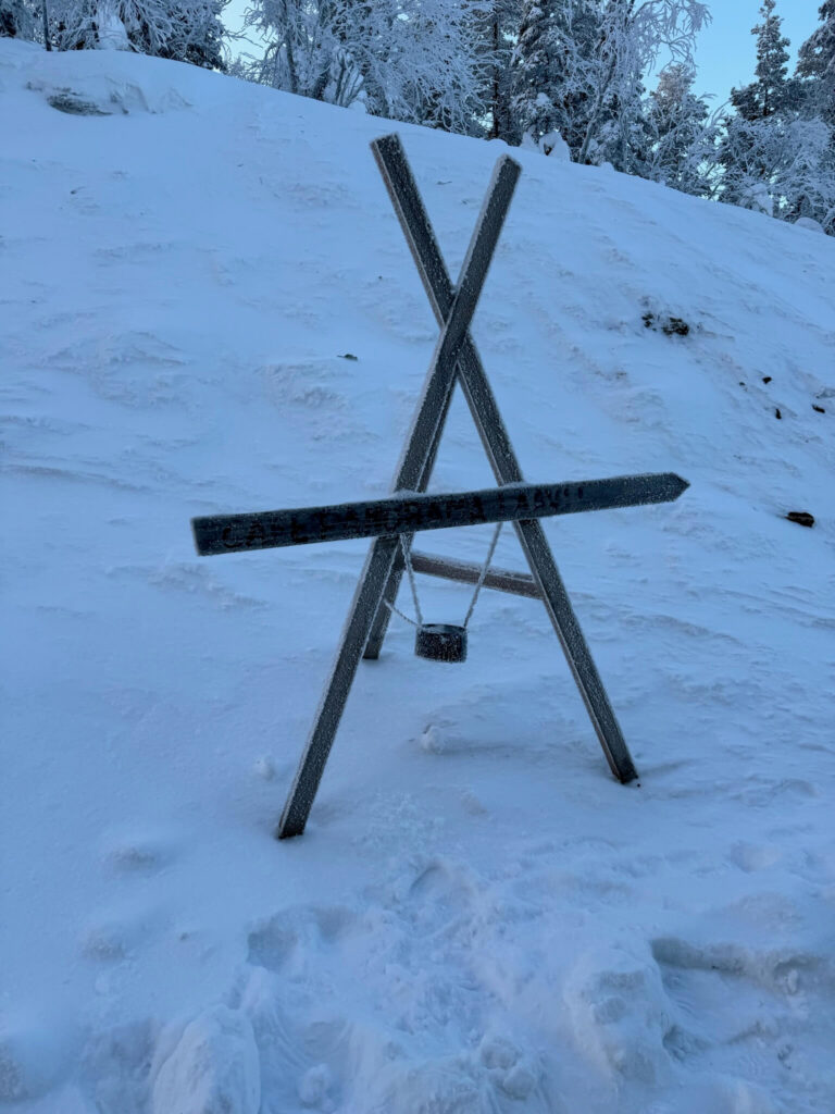 Wooden trail sign pointing towards Levi’s Secret Café