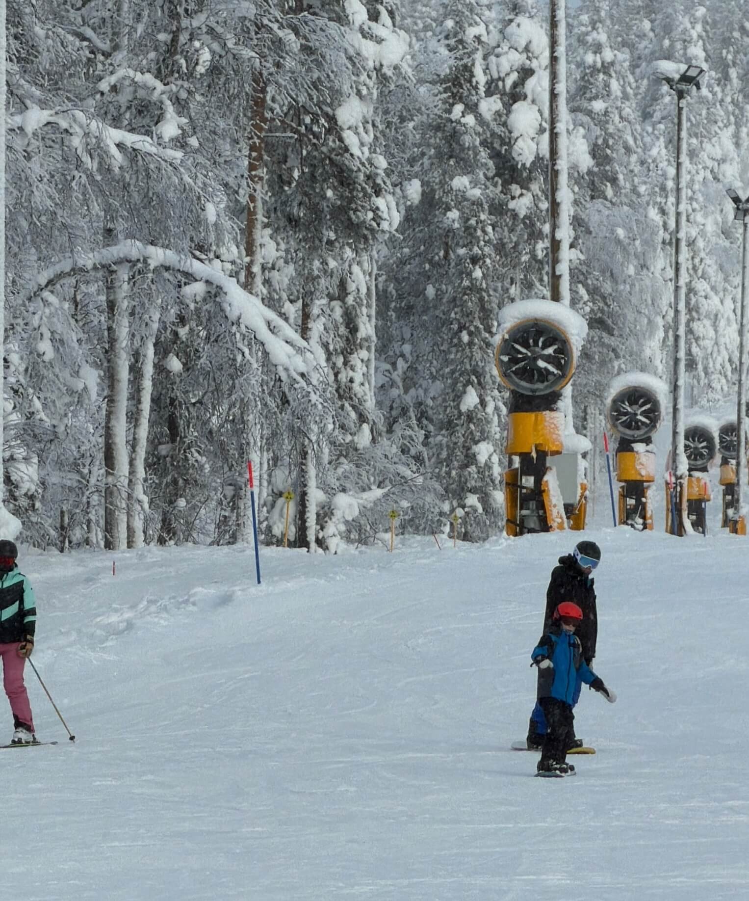 Snow cannons beside a ski slope in Levi